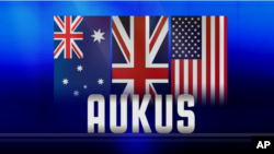 ទង់ជាតិ​នៃ​ប្រទេស​អូស្ត្រាលី អង់គ្លេស និង​អាមេរិក និង​អក្សរ «AUKUS» ដែល​ជា​អក្សរកាត់​នៃ​កិច្ចព្រមព្រៀង​ភាព​ជា​ដៃគូ​ថ្មី​មួយ​ផ្នែក​សន្តិសុខ​ត្រីភាគី​រវាង​សហរដ្ឋ​អាមេរិក និង​អង់គ្លេស​ជាមួយ​អូស្រ្តាលី។