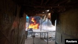 A fire is seen burning in a street during protests against price increases in Atbara, Nile River state, northeastern Sudan, Dec. 20, 2018.
