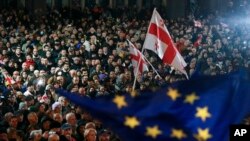 Protesters wave Georgian national and EU flags during a rally against alleged violations in recent parliamentary elections, in Tbilisi, Georgia, Nov. 4, 2024. 
