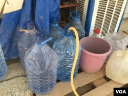Filling up water bottles in the Baharka camp on the outskirts of Irbil, in the Kurdistan region of Iraq. Considered a “five-star” camp, Baharka houses some 4,000 people, half of whom are teenagers, Aug 5, 2015. (VOA / S. Behn)