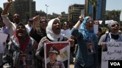 Para pendukung Hosni Mubarak, yang menentang pengadilan atas mantan presiden yang kini sakit itu, melakukan protes di Kairo dengan membawa poster Mubarak, Jumat (24/6).