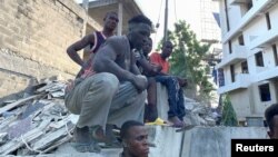 Des ouvriers observent le site de l'effondrement d'un immeuble à Ikoyi, Lagos, Nigeria, le 1er novembre 2021. 