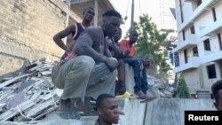 កម្មករ មើល​នៅ​កន្លែង​បាក់​អគារ​លើ​កោះ Ikoyi ក្នុង​ក្រុង Lagos ប្រទេស​នីហ្សេរីយ៉ា កាលពី​ថ្ងៃទី១ ខែវិច្ឆិកា ឆ្នាំ២០២១។