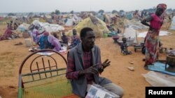 FILE - Adam Hassan sits outside his makeshift shelter in Adre, Chad, July 25, 2023. Sudan's sovereign council announced on Aug. 15, 2024, that it would allow use of the border crossing at Adre.