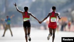 La Kényane Jemima Sumgong et la Baheïni Jepkirui Kirwa fêtent lors victoire lors du marathon, à Rio de Janeiro, Brésil, le 14 août 2016.