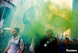 Italian Northern League supporters hold flares as they arrive at political rally led by leader Matteo Salvini, in Milan, Italy, Feb. 24, 2018.