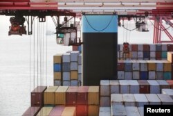 FILE - Containers are seen unloaded from the Maersk's Triple-E giant container ship Maersk Majestic, one of the world's largest container ships, at the Yangshan Deep Water Port, part of the Shanghai Free Trade Zone, in Shanghai, China, Sept. 24, 2016.