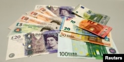 FILE - British pounds and Euro banknotes are pictured in a bank at the main train station in Munich, Germany, June 24, 2016 after Britain voted to leave the European Union in the EU BREXIT referendum.