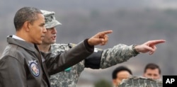 FILE - U.S. President Barack Obama, left, points towards North Korea from Observation Post Ouellette in the Demilitarized Zone, the tense military border between the two Koreas, in Panmunjom, South Korea, March 25, 2012.