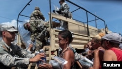 Soldiers of Puerto Rico's national guard distribute relief items to people, after the area was hit by Hurricane Maria in San Juan, Puerto Rico, Sept, 24, 2017.
