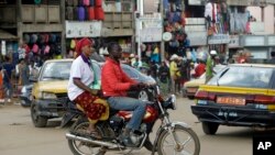 Un moto-taxi passe devant le marché Mokolo à Yaoundé, Cameroun, le 11 octobre 2018. (AP Photo/Sunday Alamba)