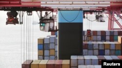 FILE - Containers are seen unloaded from the Maersk's Triple-E giant container ship Maersk Majestic, one of the world's largest container ships, at the Yangshan Deep Water Port, part of the Shanghai Free Trade Zone, in Shanghai, China, Sept. 24, 2016. 