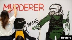 Anti-government protesters make a mural depicting the student protester who was shot by police with live ammunition in Hong Kong, Oct. 2, 2019. 
