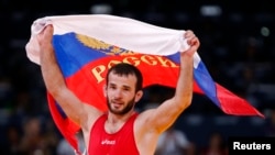 Russia's Dzhamal Otarsultanov celebrates after defeating Georgia's Vladimer Khinchegashvili on the final of the Men's 55Kg Freestyle wrestling during the London 2012 Olympic Games Aug. 10, 2012.