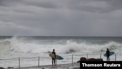 Surfers prepare to enter the water on May 22, 2020, amid the easing of coronavirus disease restrictions in Sydney, Australia.