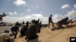 Libyan rebels duck for cover during a failed attempt to take the town of Ajdabiya from Moammar Gadhafi's forces, March 21, 2011