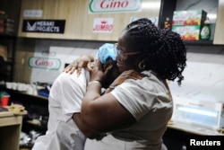 Nigerian Chef Hilda Baci, 27, is hugged by her mother, Lynda Ndukwe, after attempting to break the Guinness World Record for the longest cooking time by an individual, in Lagos, Nigeria May 15, 2023. (REUTERS/Temilade Adelaja)
