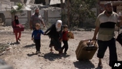 Devojčica pognuta beži sa braćom u deo grada al-Rifai, dok se iračke specijalne jedinice bore protiv Islamske države u zapadnom Mosulu, irak, 17. maja 2017. (AP Photo/Maya Alleruzzo)