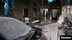 Petugas medis memeriksa kerusakan di luar sebuah rumah sakit lapangan setelah terjadinya serangan udara di kawasan al-Maadi yang dikuasai pemberontak di Aleppo, Suirah (28/9). (foto: REUTERS/Abdalrhman Ismail)