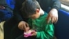 Mohammed, age 5, uses his mother's smartphone to play games earlier this year. Before his family fled from the Syrian city of Aleppo to Istanbul, Mohammed’s grandfather was killed. (photo courtesy Liv Marte Nordhaug)
