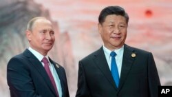 FILE - Chinese President Xi Jinping, right, and Russian President Vladimir Putin pose for a photo at the Shanghai Cooperation Organization (SCO) Summit in Qingdao in eastern China's Shandong Province, June 10, 2018.