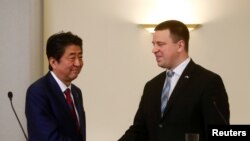 아베 신조(왼쪽) 일본 총리와 위리 라타스 에스토니아 총리가 12일 탈린에서 공동 기자회견 직후 악수하고 있다.
