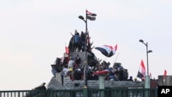 Anti-government protesters control the barriers set by Iraqi security forces to close the bridge leading to the Green Zone during a demonstration in Baghdad, Iraq, Oct. 29, 2019. 