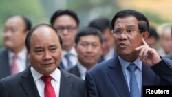 A man walks toward a coronavirus warning sign outside a medical center in Manchester, Britain.