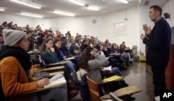 In this Wednesday Feb. 1, 2017, photo, Brooklyn College chemistry professor Alexander Greer, right, lectures during his class, in New York. (AP Photo/Bebeto Matthews)