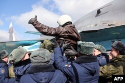 A handout picture taken on March 15, 2016 and released by the Russian Defence Ministry shows a Russia's air force pilot, who returned from the Hmeimim military base in Syria's Latakia province.