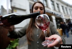 Whether moderate amounts of wine are really good for your heart is debated among health experts. Here, a shop assistant pours wine during a wine festival in Tbilisi, Georgia, 2017. (REUTERS/David Mdzinarishvili).