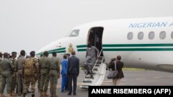 Les chefs militaires maliens saluent l'ancien président nigérian Goodluck Jonathan à son arrivée à l'aéroport de Bamako avant une rencontre entre les chefs militaires maliens et une délégation de la CEDEAO qu'il dirige le 22 août 2020.