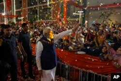 Supporters greet Indian Prime Minister Narendra Modi as he arrives at Bharatiya Janata Party headquarters in New Delhi on June 4, 2024.
