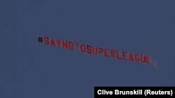 Sebuah spanduk bertuliskan #TolakLigaSuper diterbangkan di atas stadion sebelum laga di Leeds, Inggris, Senin, 19 April 2021. (Foto: Clive Brunskill/Reuters)