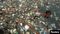 Seorang anak mengumpulkan botol-botol plastik bekas untuk dijual di Pantai Marunda, Jakarta (foto: dok). Sebuah panel iklim PBB Senin (9/8) mengatakan bahwa perubahan iklim “benar-benar disebabkan oleh aktivitas manusia”. 