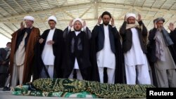 Afghan people offer funeral prayers behind the body of a civilian killed in Sunday's deadly suicide attack at a voter registration center, in Kabul, Afghanistan, April 23, 2018. 