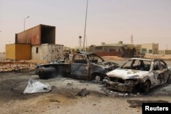 FILE - Vehicle wreckages are seen after a suicide car bomber blew himself at a checkpoint near Misrata, Libya, May 21, 2015.