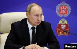 Russian President Vladimir Putin visits the Joint Headquarters of the Russian armed forces, in an unknown location