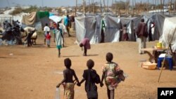 Three children walk through a camp for internally displaced persons at the United Nations Mission to South Sudan (UNMISS) base in Juba, Jan. 9, 2014.