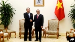 North Korean Foreign Minister Ri Yong Ho, left, poses with Vietnamese Prime Minister Nguyen Xuan Phuc for a photo during a meeting at the Government Office in Hanoi, Vietnam, Saturday, Dec. 1, 2018.