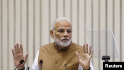 FILE - India's Prime Minister Narendra Modi gestures as he addresses the gathering during the 'Global Mobility Summit' in New Delhi, India, Sept. 7, 2018.