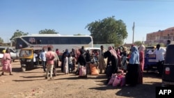 People displaced by the conflict in Sudan gather with belongings after they fled Wad Medani, the capital of Jazeerah state, on Dec. 18, 2023.