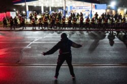 A demonstrator heckles authorities who advanced into a gas station after issuing orders for crowds to disperse during a protest against the police shooting of Daunte Wright, April 12, 2021, in Brooklyn Center, Minnesota.