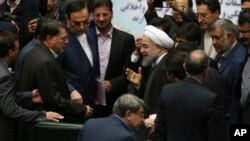 Presiden Iran Hassan Rouhani, tengah, saat disambut oleh para anggota DPR di parlemen untuk menyampaikan draft anggaran negara Iran tahun depan dan rencana pembangunan di Teheran, 17 Januari 2016. 