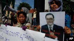 អ្នក​គាំទ្រ​គណបក្ស​ប្រឆាំង​កាន់​បដា​រូបថត​​សមាជិក​ព្រឹទ្ធសភា លោក​ ហុង សុខហួរ​ ក្នុង​អំឡុង​បាតុកម្ម​មួយ​នៅ​មុខ​សាលា​ដំបូង​រាជធានី​ភ្នំពេញ​កាល​ពី​ថ្ងៃទី​១៥ ខែ​សីហា ឆ្នាំ​២០១៥។