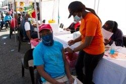 FILE - A patient receives a Johnson &amp; Johnson vaccine at a pop-up vaccination center, at the Bare taxi rank in Soweto, South Africa, Aug. 20, 2021.