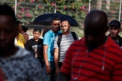 Migrants wait for donated food at the Puerta Mexico international bridge, Matamoros, Mexico, June 27, 2019. Hundreds of migrants have been waiting for their numbers to be called to have a chance to request asylum in the U.S.