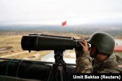 FILE - A Turkish soldier watches the border line between Turkey and Syria near the southeastern village of Besarslan, in Hatay province, Turkey, Nov. 1, 2016.