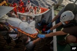 Aid workers of Proactiva Open Arms recover dead bodies of migrants from inside a rubber boat in the Mediterranean Sea, about 15 miles north of Sabratha, Libya on July 25, 2017.
