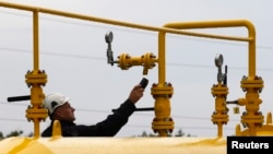 FILE - A worker makes the final checks of the new gas inter connector linking Poland and the Czech Republic before its opening in Cieszyn, Poland, Sept. 14, 2011. 